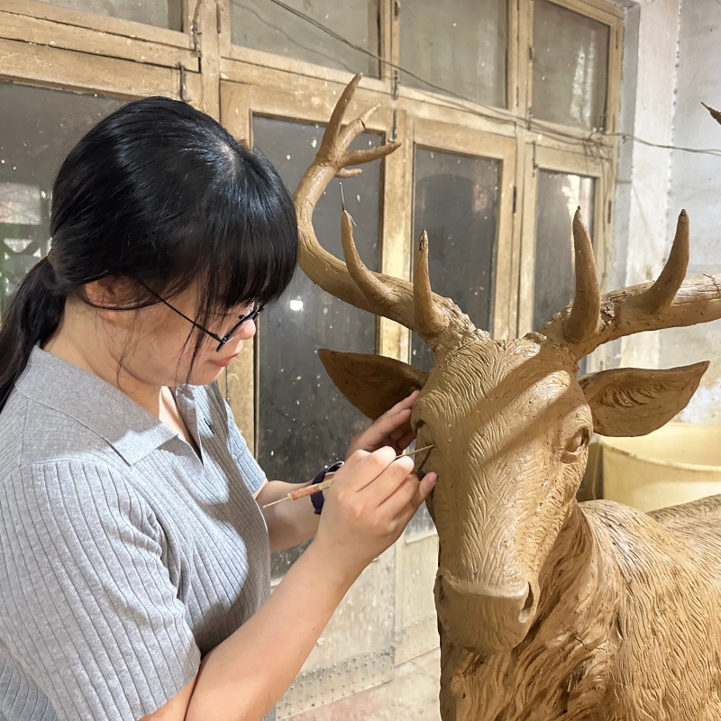 YouFine artisan working on a clay mould for elk statue in the foundry